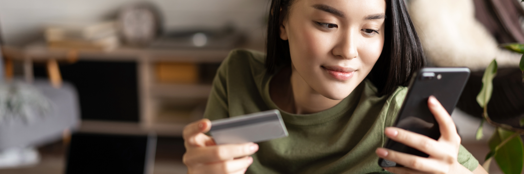 Portrait of two women, senior and young using laptop and credit card