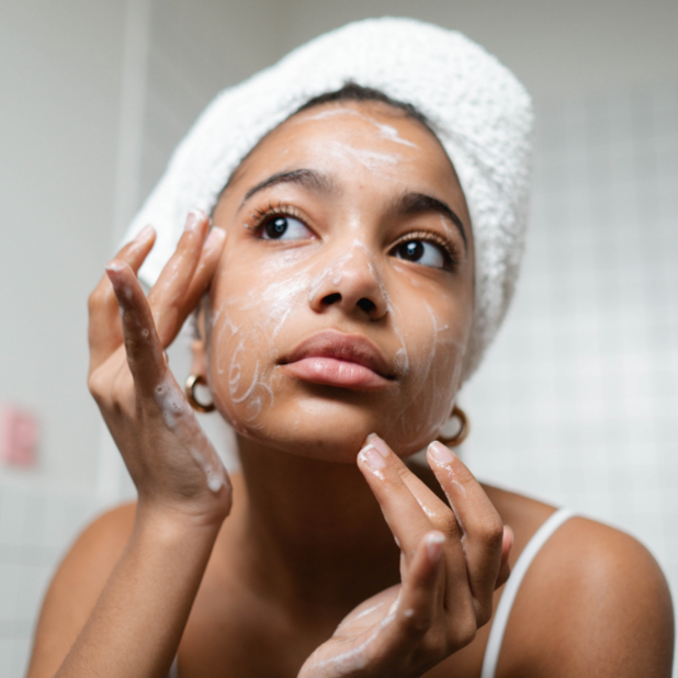 Young woman carefully cleansing face.