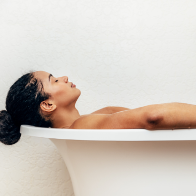 Side view of black woman having a bath in a luxurious bathtub