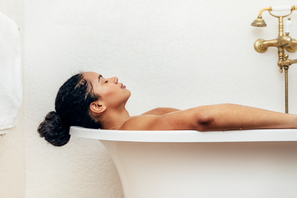 Side view of black woman having a bath in a luxurious bathtub