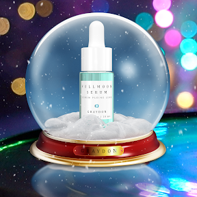 A glass bottle containing an aquamarine-coloured facial serum in a snowglobe with multicoloured lights in the background. 