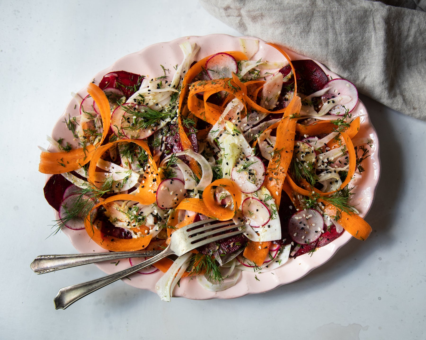 Fennel and root vegetable salad with Za’atar vinaigrette on a light pink serving platter